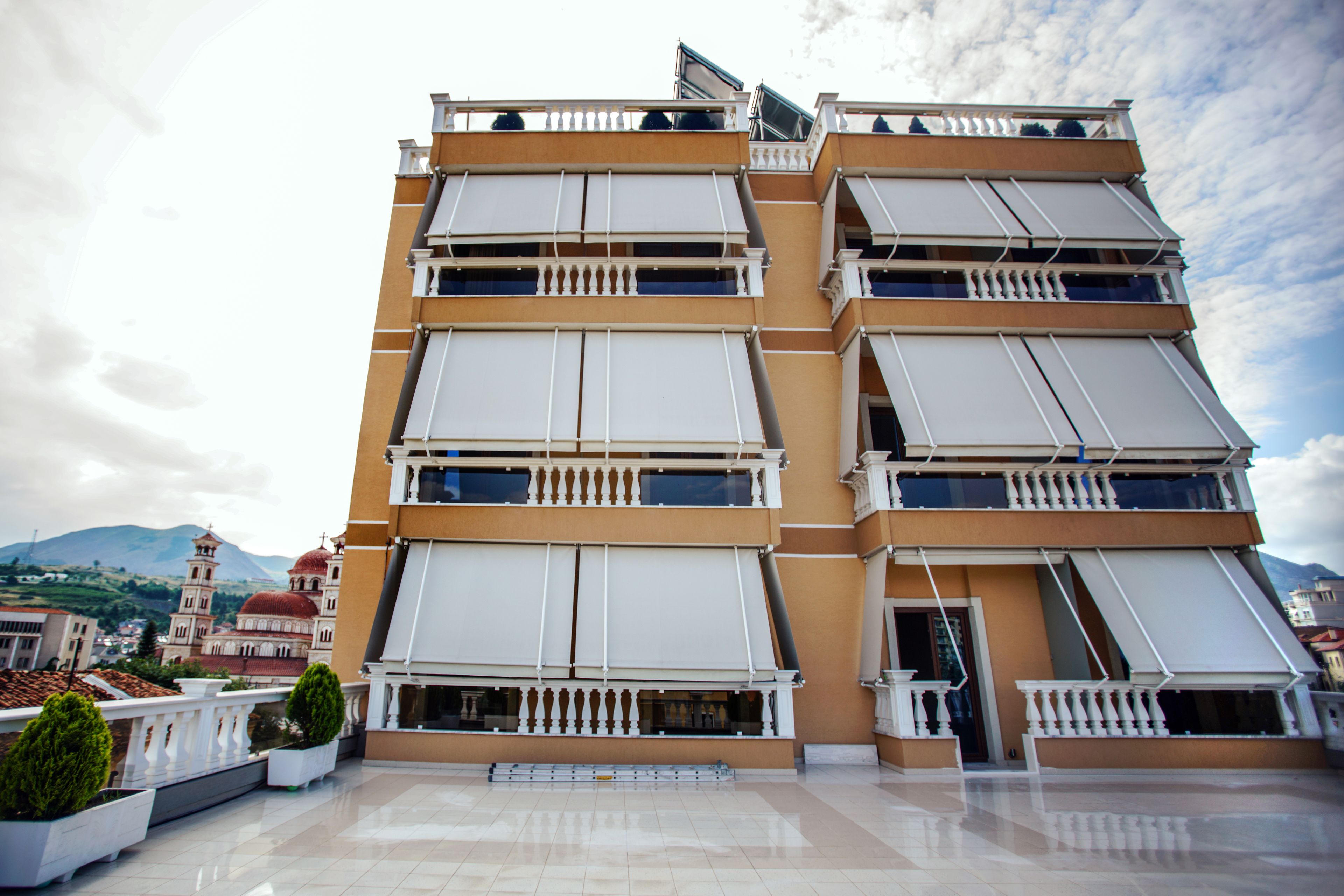 A multi-story building with balconies and large windows.