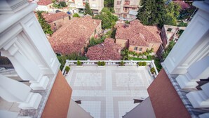 A view of a courtyard with tiled roofs and a white fence. - Hotel Borova (Korçë)