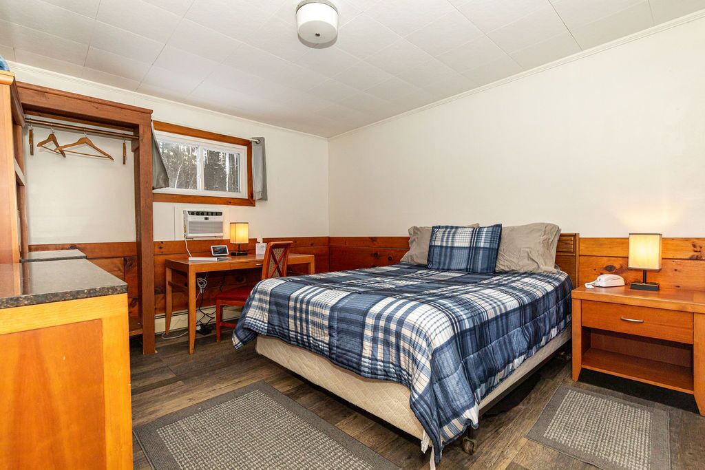 A bedroom with a bed, a desk, and a chair.