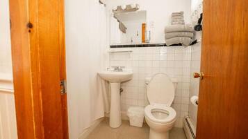 Ein Badezimmer mit einem weißen Waschbecken, einer Toilette und einem Spiegel über dem Waschbecken.