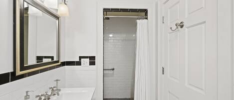 A bathroom with a white sink, mirror, and shower area.
