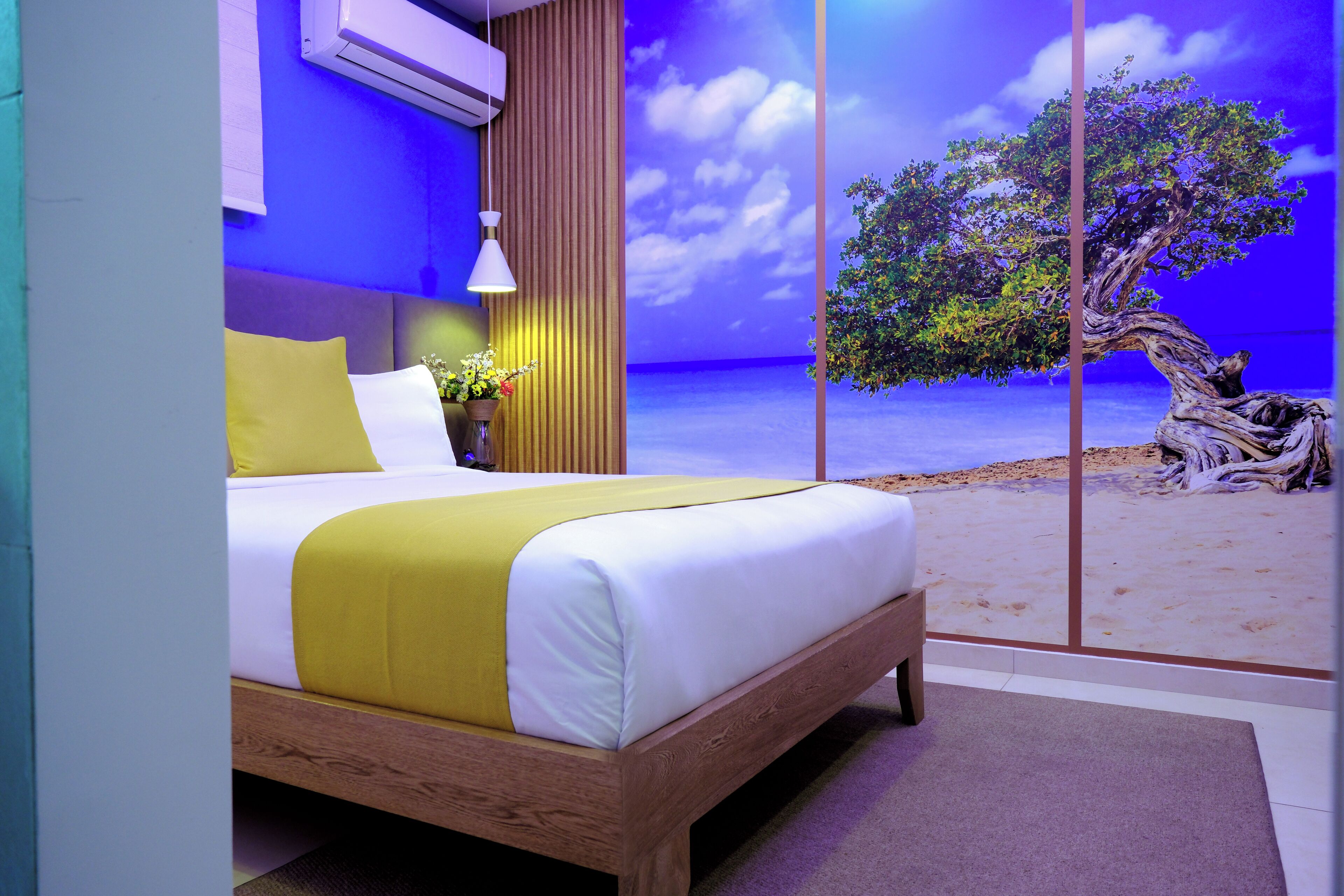 Une chambre à coucher moderne avec un lit, une table de chevet et un climatiseur fixé au mur.