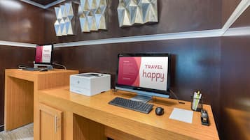 A reception desk with a computer, keyboard, mouse, and a printer.