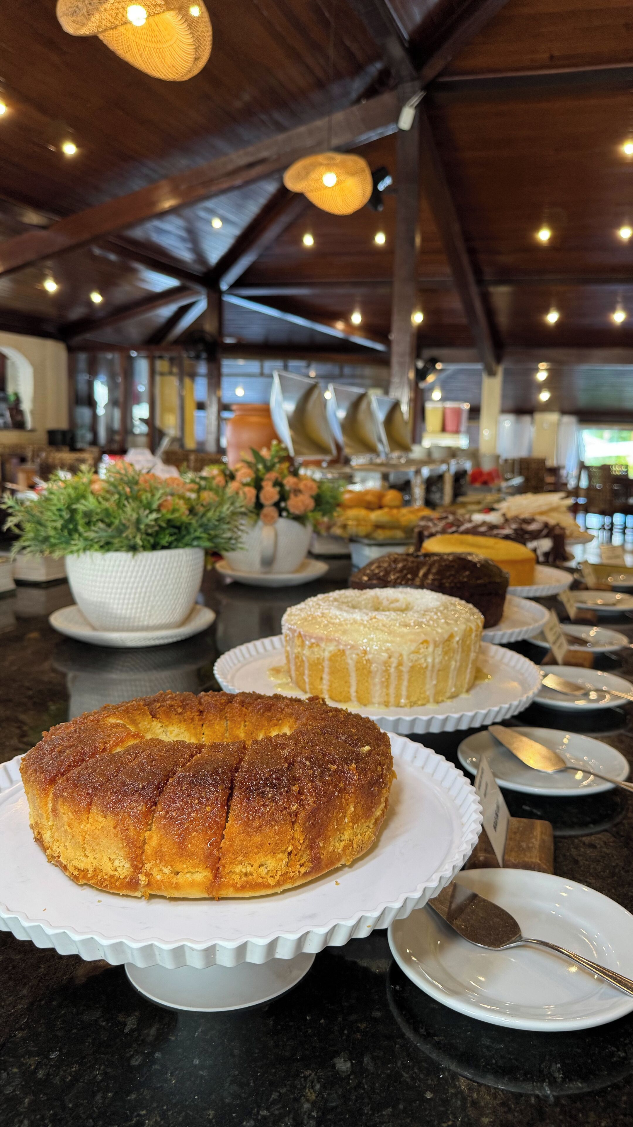 Een buffet met diverse desserts, waaronder een taart en een bundt cake, op een marmeren aanrecht.