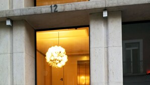 A building entrance with a large, illuminated spherical light fixture above the door.