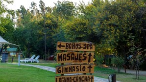 Un poste de madera con indicaciones a diferentes servicios, como un spa, un gimnasio y un lago.