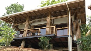 Un bâtiment à deux étages, doté d’un toit en bambou et d’un balcon.