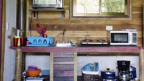 Une cuisine compacte équipée d’un four à micro-ondes, d’un grille-pain et d’un évier.