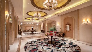 A spacious hotel lobby with chandeliers, a floral carpet, and a reception desk. - Holiday Inn Fuzhou New Port by IHG (Fuzhou)