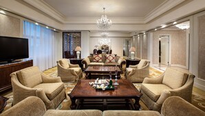 A spacious living room with a large television, comfortable seating, a chandelier, and a decorative wall piece. - Holiday Inn Fuzhou New Port by IHG (Fuzhou)