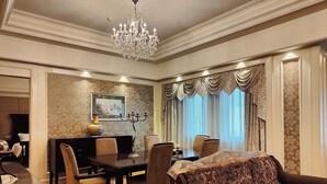 A dining area with a chandelier, a dining table, chairs, and a sofa. - Holiday Inn Fuzhou New Port by IHG (Fuzhou)