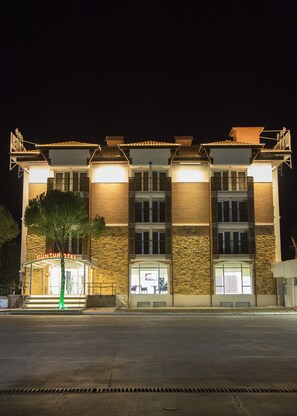 Vista frontal de la propiedad por la tarde o noche