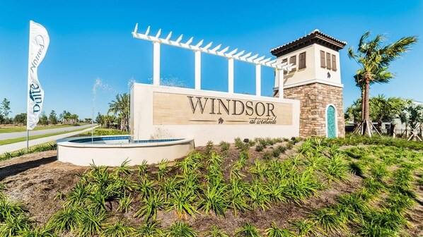 A sign for 'Windsor at Wildwood' with a pool and a pergola.