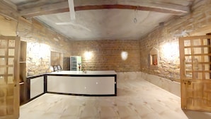 A room with stone walls, a white reception desk, and a small window.