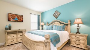 A bedroom with a large bed, two bedside tables, a dresser, a painting, and a decorative wall piece. - The Encore Club #7 - 8 Bed 7 Baths Villa (Kissimmee)