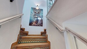 Una escalera con barandales ornamentales y un borde decorativo de azulejos.