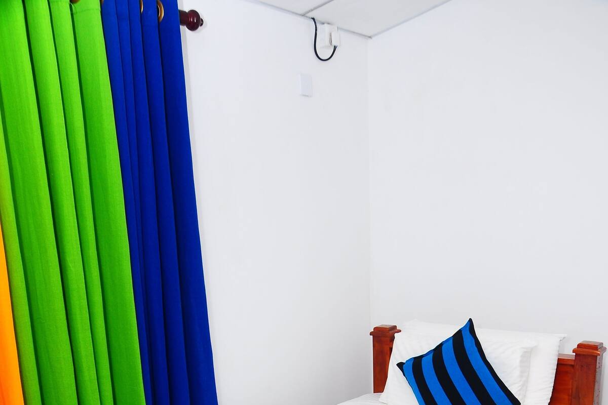 A bed with a striped bedspread, a pillow, and a bedside table.