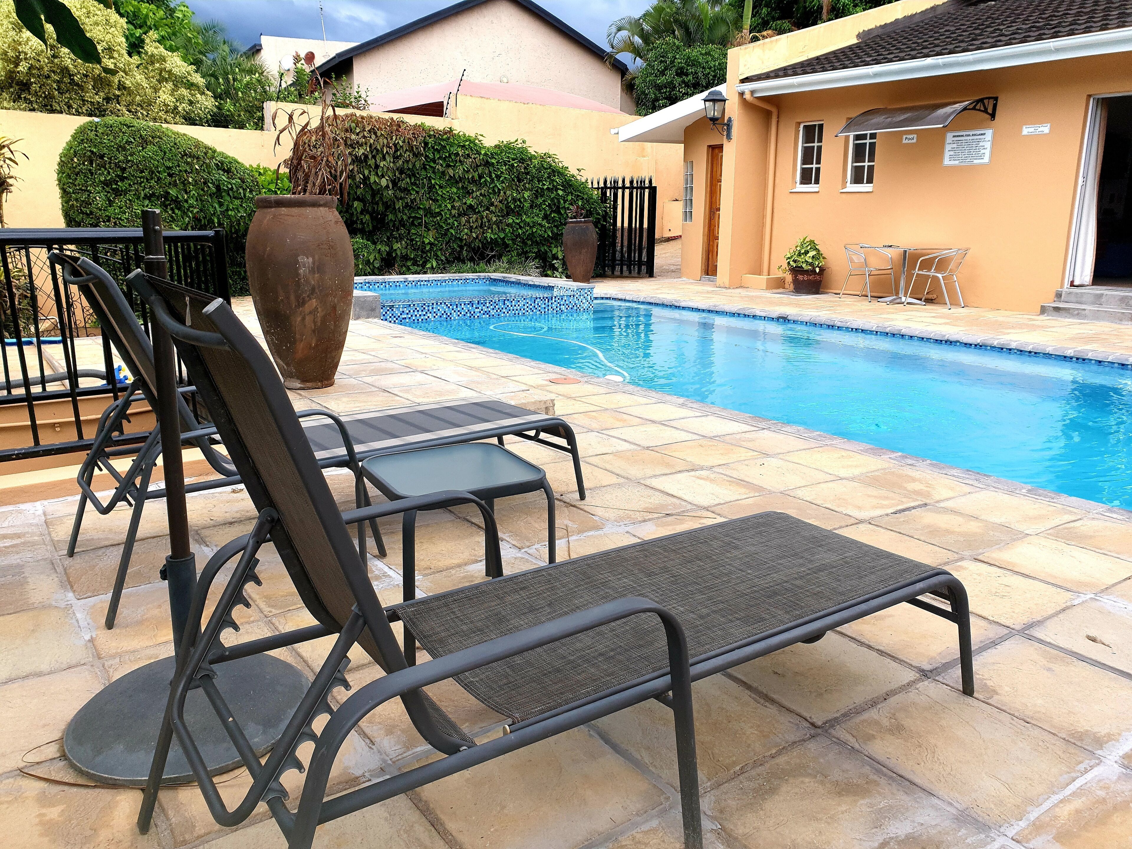 A poolside area with lounge chairs and a tiled deck.