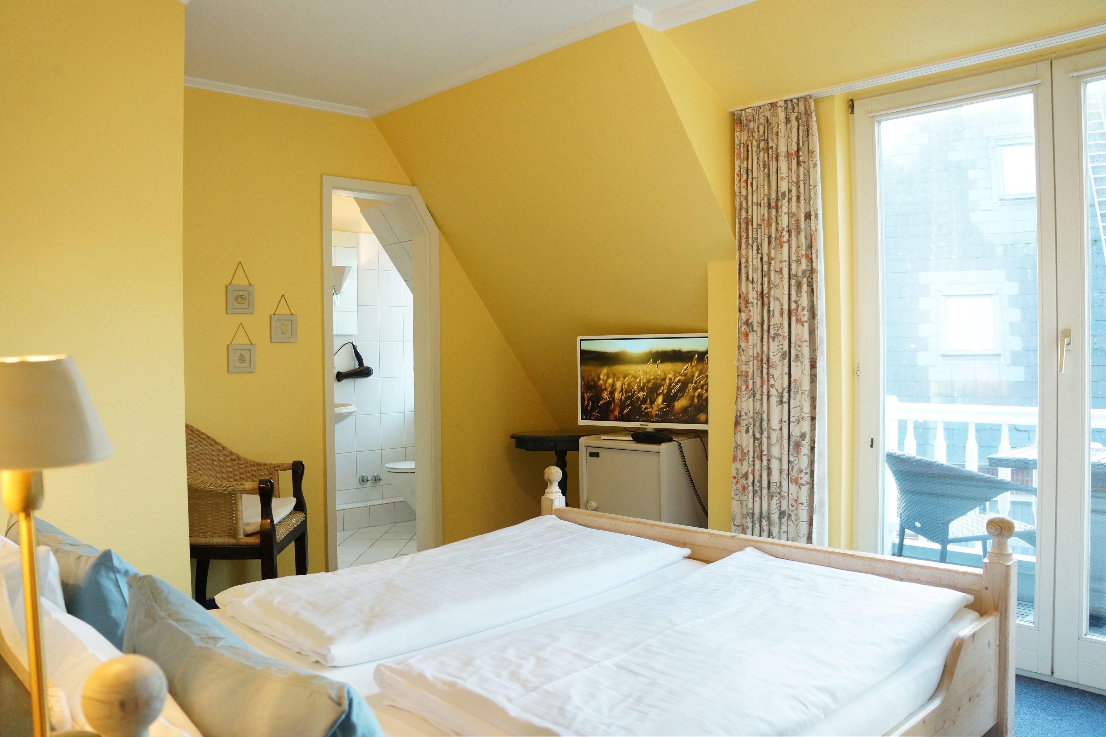 Een hotelkamer met een bed, een stoel, een televisie en uitzicht.