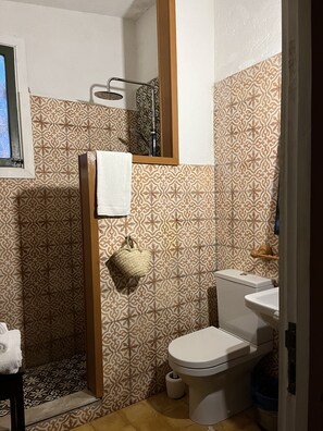 A bathroom with patterned tiles, a toilet, a sink, and a shower area. - Gite Dayet Aoua (Dayat Aoua)