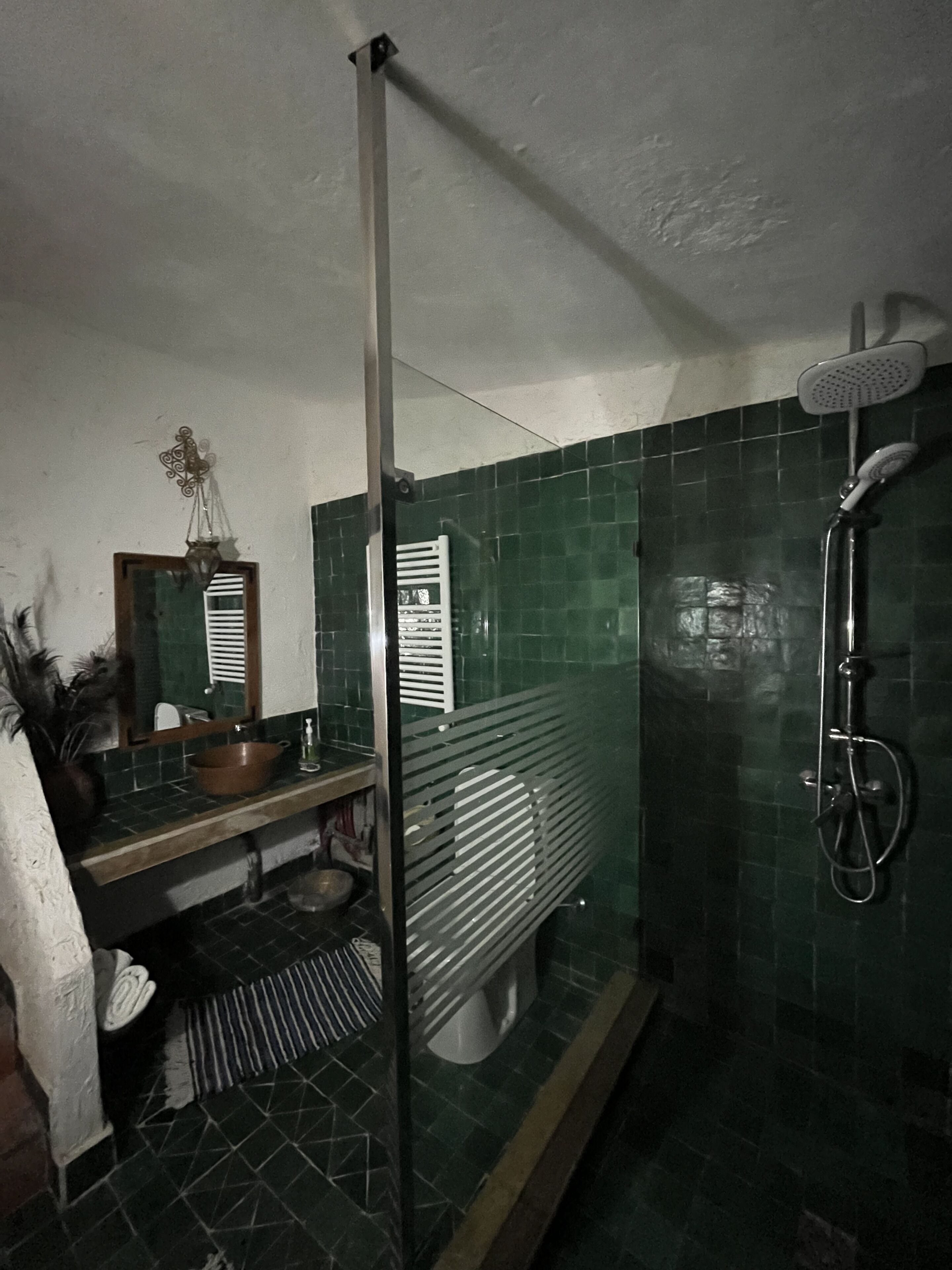 Un baño con ducha, lavamanos y espejo.