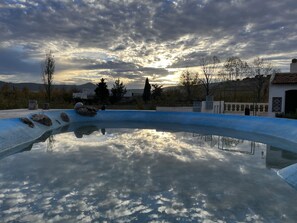 A swimming pool with a clear reflection of the sky and surrounding landscape. - Gite Dayet Aoua (Dayat Aoua)