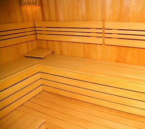Un sauna en bois avec des bancs et une banquette.