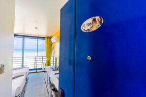 A room with a large window, a blue door, and a view of the beach. - Play Phala Beach Rayong (Ban Chang)