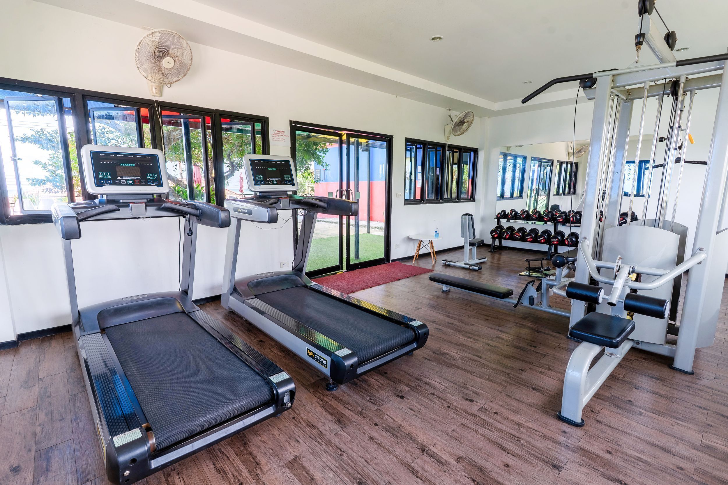 A gym with treadmills, weight machines, and a mirror.