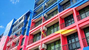 A multi-story building with balconies and air conditioning units.