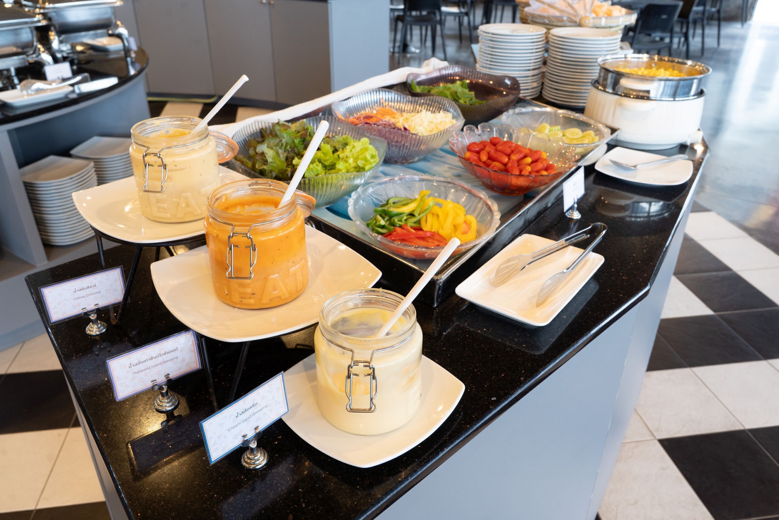 A buffet with various food items and condiments.