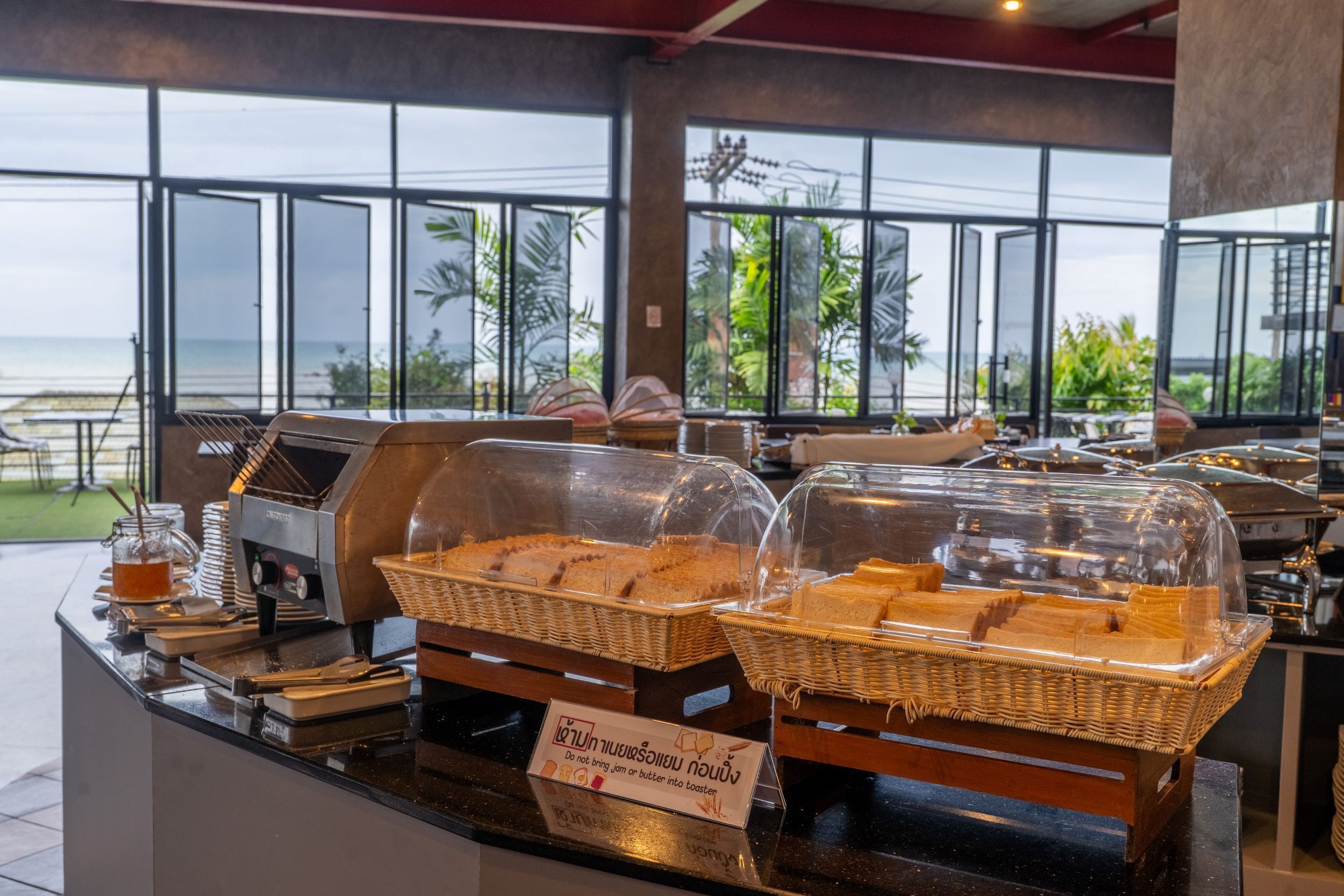 Ein Buffet mit abgedeckten Speisenauslagen und einem Schild, das darauf hinweist, dass fremde Speisen nicht erlaubt sind.