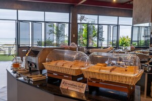 A buffet setup with covered food displays and a sign indicating no outside food.
