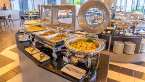 Ein Buffet mit mehreren Speisenstationen und einem großen Fenster im Hintergrund.