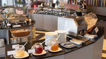 A buffet setup with various food items and utensils.