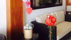 A living room with a sofa, a mirror, and a decorative heart garland. - Lindi Hotel Baguio (Baguio)