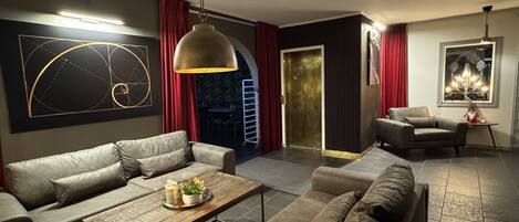 A modern living room with a sofa set, a coffee table, and a pendant light.