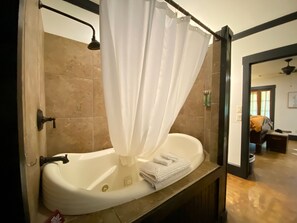 Une salle de bain avec une baignoire, un rideau de douche et une serviette posée sur le bord.