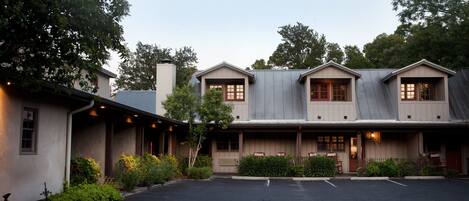 A two-story building with a covered porch, a garage, and a driveway.