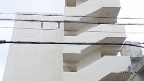 Ein modernes Gebäude mit rotem Eingang und einer darunterliegenden Tiefgarage.