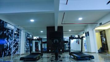 Un gimnasio con cintas de correr, una banca de pesas y una estructura para sentadillas.