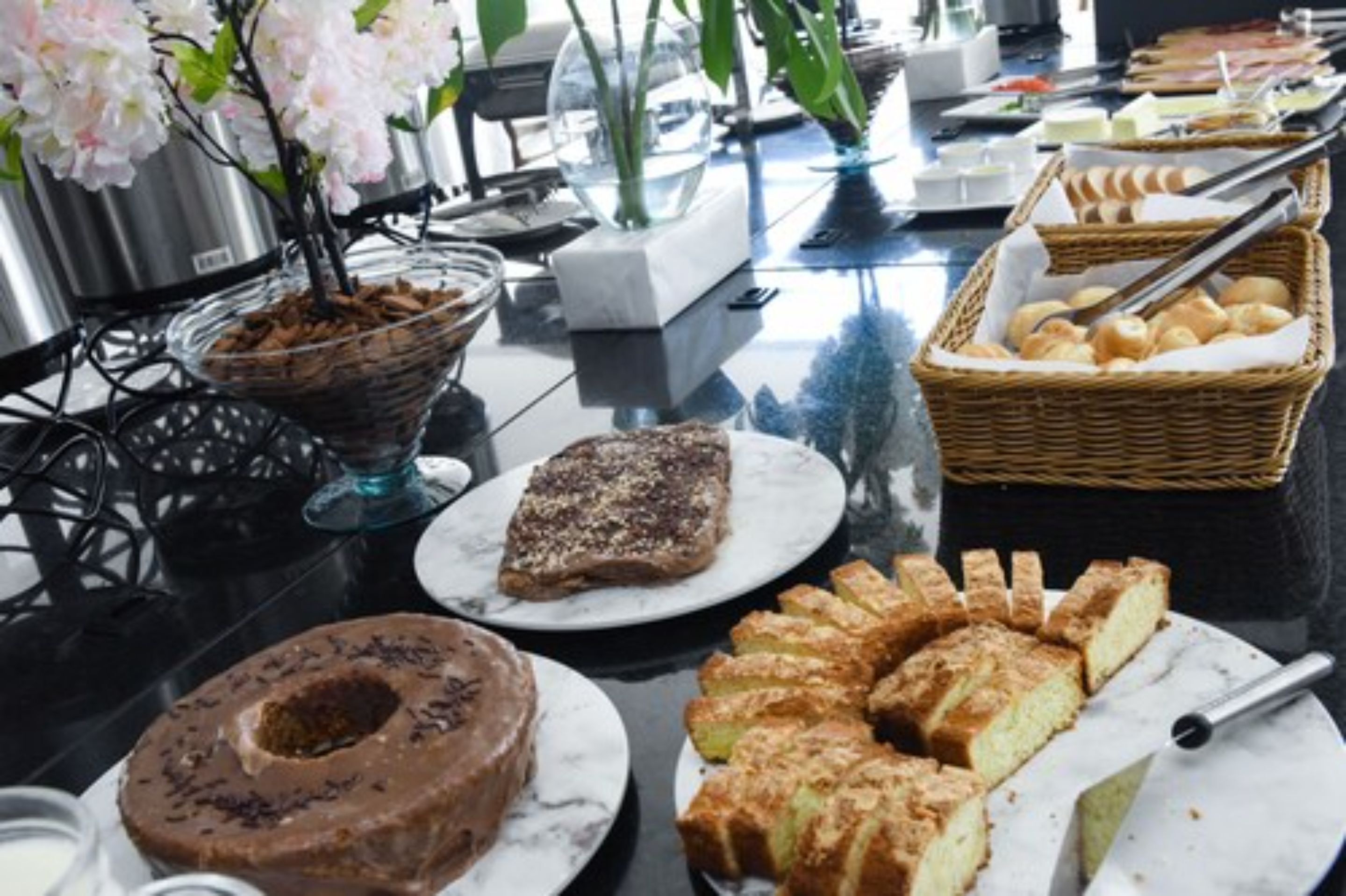 A buffet table with various pastries and desserts, including a chocolate cake and a fruit tart.