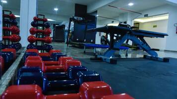 A gym with exercise equipment, including dumbbells and a treadmill.