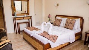 A hotel room with a bed, a desk, a chair, and a mirror. - Marick Beach Resort (Carmen)