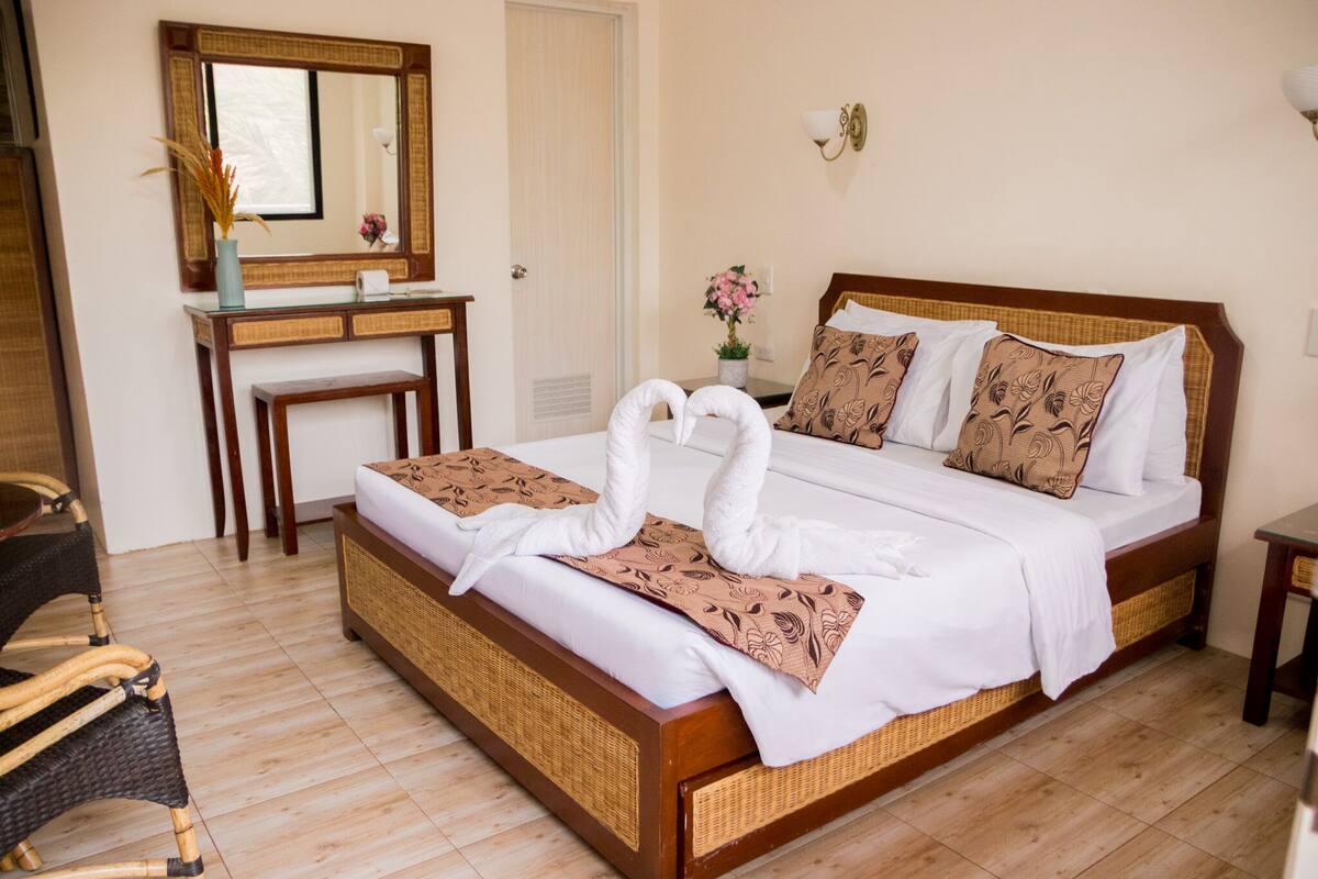 Ein Hotelzimmer mit Bett, Schreibtisch, Stuhl und Spiegel.