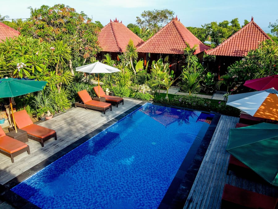 Een buitenzwembad, ligstoelen bij het zwembad