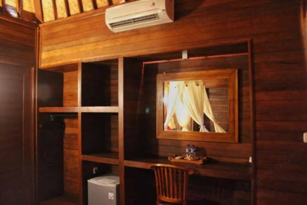 Un intérieur en bois avec un climatiseur fixé au mur, un tableau encadré, une petite table avec un plateau et une chaise.