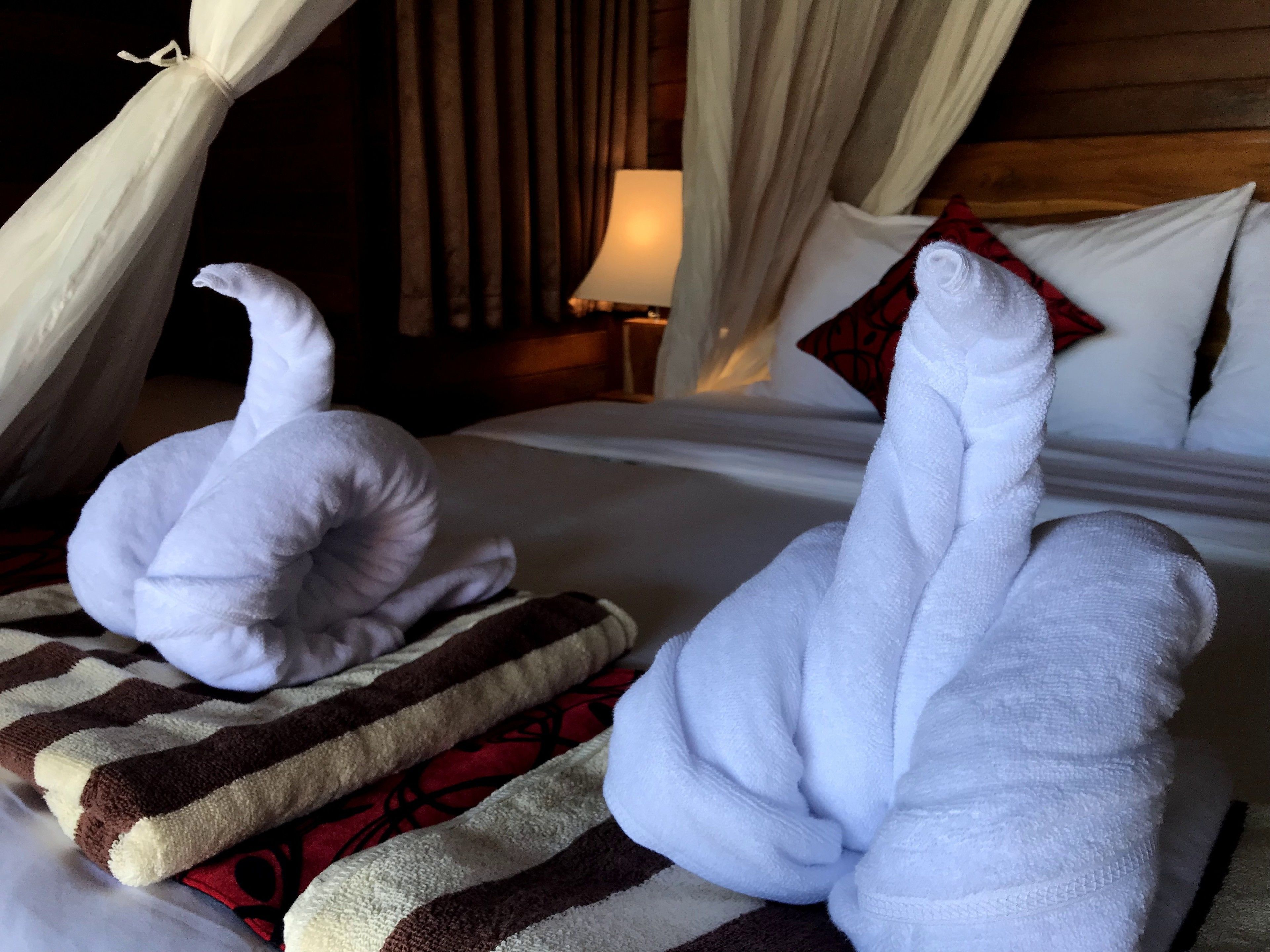 A bed with white pillows and a striped blanket.