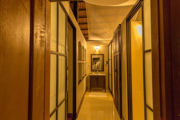A narrow hallway with wooden doors and a mirror on the wall. - Pou Villa (Luang Namtha)