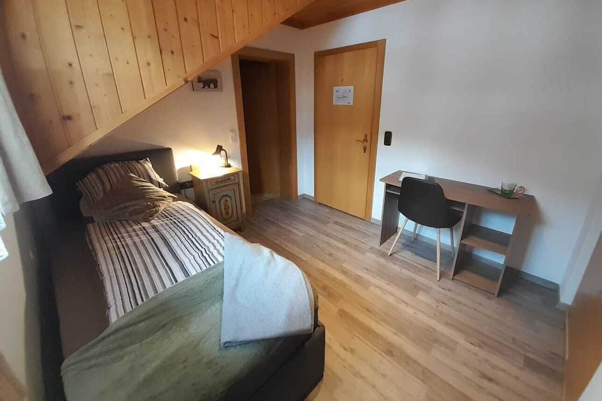 Une chambre à coucher avec un lit, un bureau et une porte.